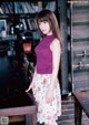 A woman standing in front of a wooden table.