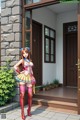 A woman in a sailor outfit standing in front of a house.