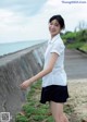 A woman in a white shirt and black skirt posing for a picture.