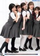 A group of young women in school uniforms posing for a picture.