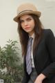 A woman in a suit and tie sitting on a chair.