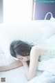 A woman laying on a bed with her head on a pillow.